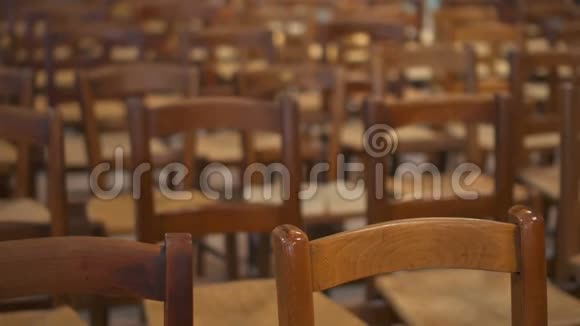 天主教堂里的木皮寺庙里一排排棕色的木椅空厅周围没有人视频的预览图