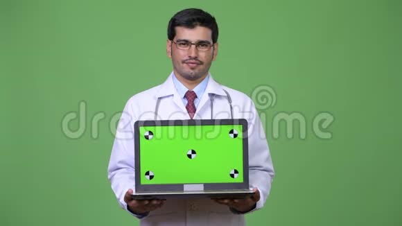 年轻英俊的波斯医生带着笔记本电脑视频的预览图
