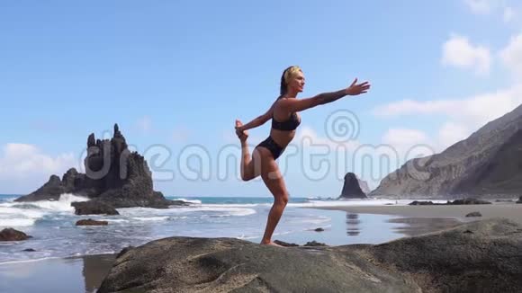 一条腿站在石头上做瑜伽平衡的女孩心灵的平静健康的生活方式平衡与和谐和平视频的预览图