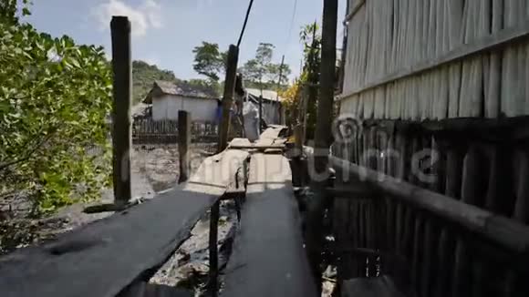 在菲律宾贫民窟为穷人建造的房子从高水板上的木桥人和家庭的贫困视频的预览图