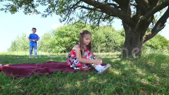 男孩正在给漂亮的女孩送花恋爱中的年轻夫妇阳光公园里两个可爱的孩子绿色的快乐视频的预览图