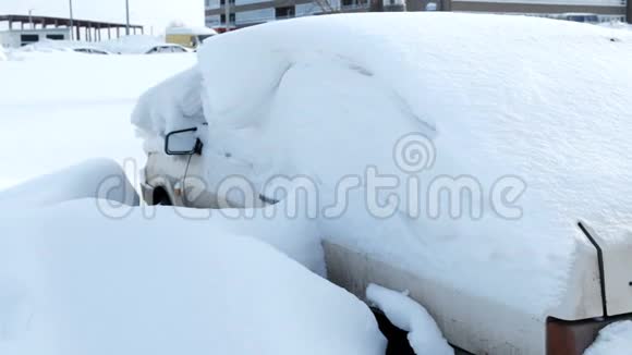 肮脏的白色汽车覆盖着城市的雪侧视视频的预览图