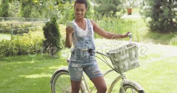 带着自行车和电话的迷人女人视频的预览图