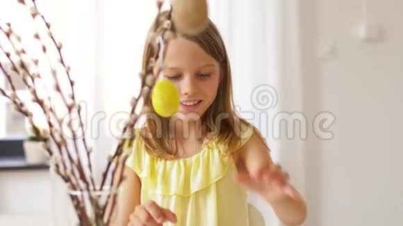 家里用彩蛋装饰柳树的女孩视频的预览图