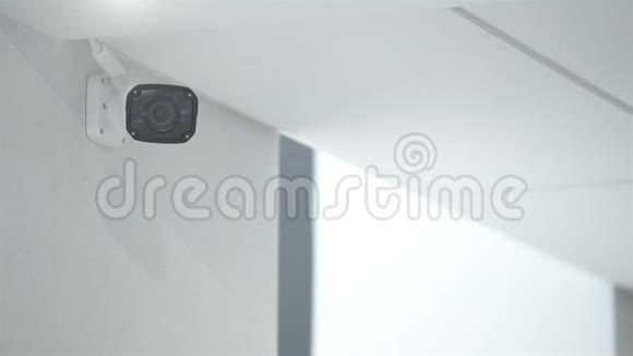 监控摄像头挂在白色墙上的办公楼里视频的预览图
