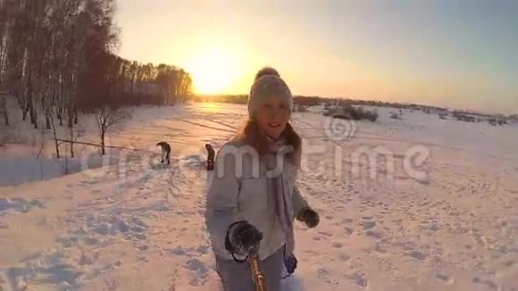 女孩用雪管升到雪山慢动作冬天的雪景积极休息运动视频的预览图