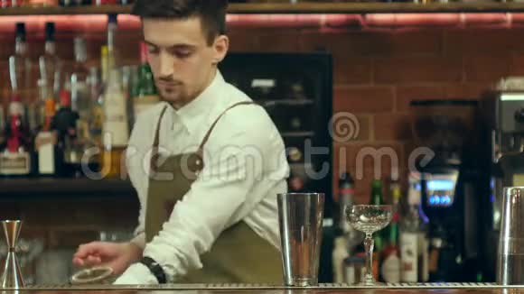 年轻的胡子酒吧老板用两种酒精来准备鸡尾酒饮料一种是用不寻常的甜糖浆另一种是装饰它视频的预览图
