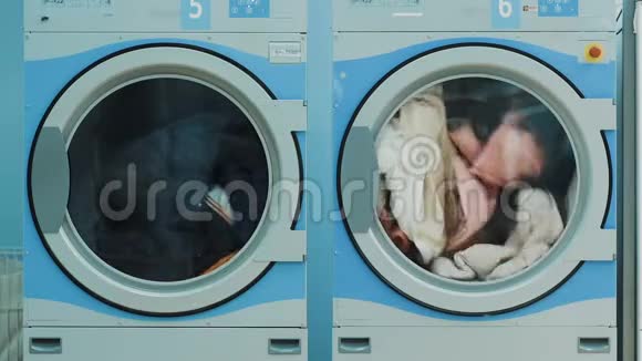公共洗衣房有两台带旋转桶的大型洗衣机视频的预览图