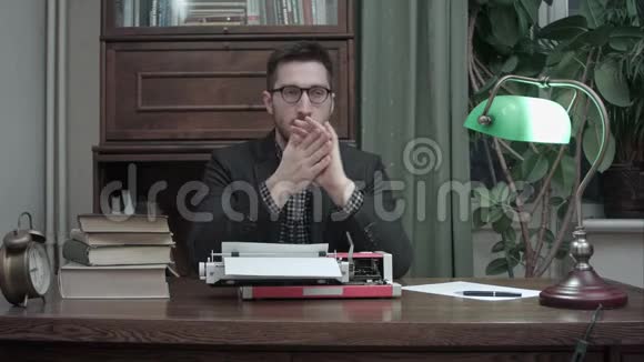 体贴的作家坐在打字机前等待他的新书的灵感视频的预览图
