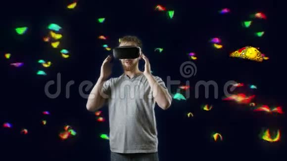 在蝴蝶云互动触摸虚拟蝴蝶黑中佩戴VR眼镜的男子视频的预览图