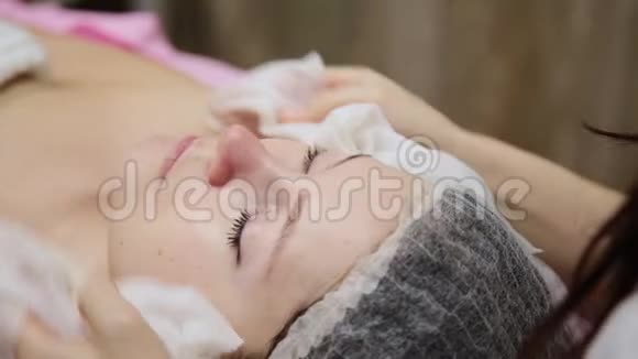 非常漂亮的女孩在温泉沙龙按摩脸前用餐巾擦脸视频的预览图