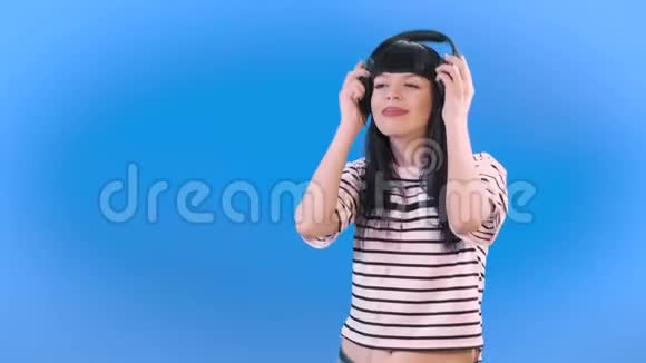 一个黑发女孩戴着耳机听音乐微笑4k视频的预览图