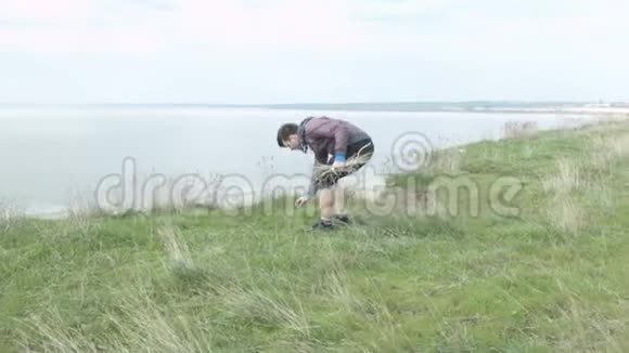 大自然中的一位游客采集干草作为篝火视频的预览图