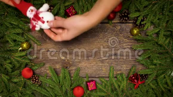 女人手创造圣诞装饰圣诞树上的树枝木纹上有圆锥和圣诞装饰视频的预览图