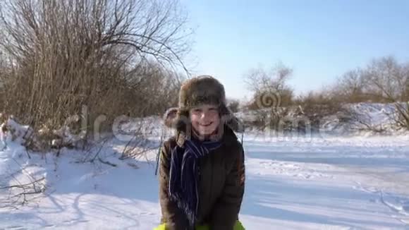 孩子们把雪洒在自己身上在冬天的公园里微笑着冰冻的晴天情感男孩嘲笑视频的预览图