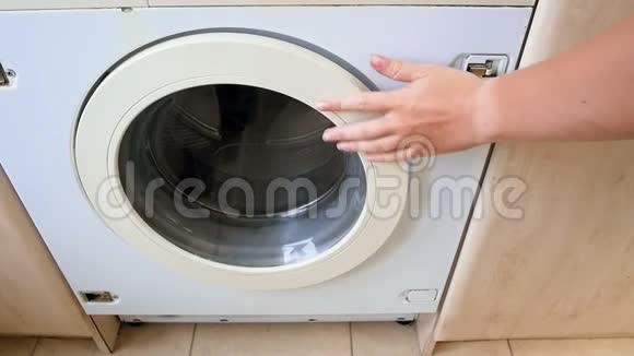 年轻女子的慢镜头打开了洗衣机把衣服扔到里面视频的预览图