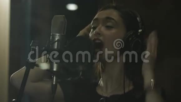 在录音室里有一个美丽的声音的女孩录制了一首歌视频的预览图