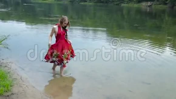 神秘的女孩有创意的化妆穿着民族红色的裙子在水中行走视频的预览图