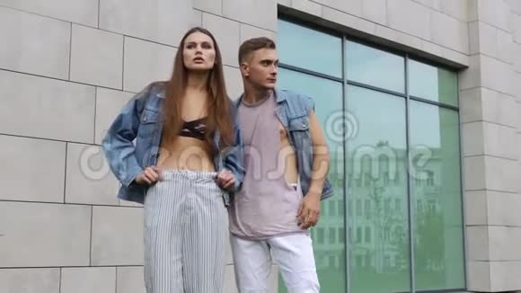 男人和女人穿着休闲的街头服装摆在灰色的墙前视频的预览图