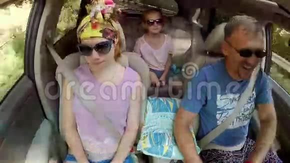 爸爸和两个女儿坐车去艾佩特里山爸爸边开车边说话所有人都戴太阳镜视频的预览图