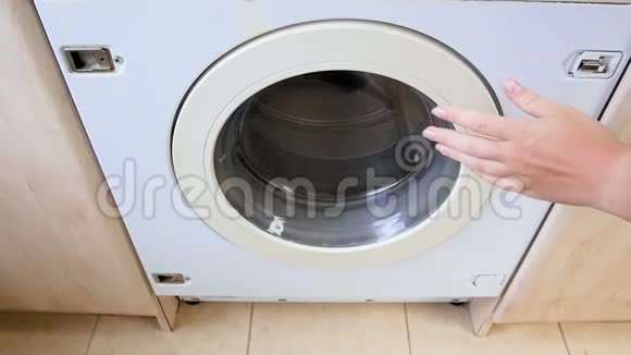 女子手在洗衣机洗衣服的慢动作视频视频的预览图