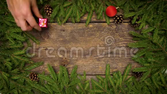 女人手创造圣诞装饰圣诞树上的树枝木纹上有圆锥和圣诞装饰视频的预览图