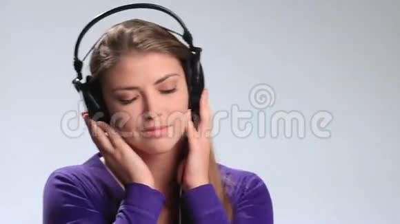可爱的年轻女子听耳机音乐视频的预览图