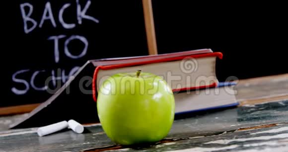 桌子上有苹果书粉笔和石板视频的预览图