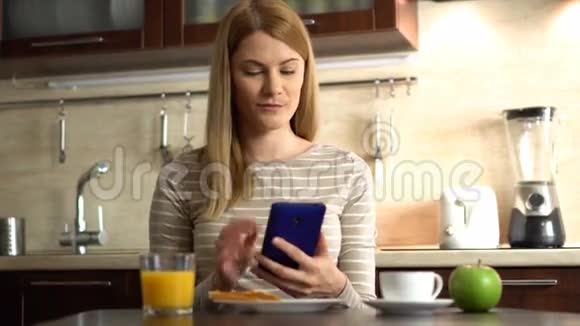 美丽的元女在室内用餐在社交媒体上分享照片视频的预览图