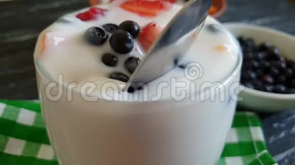 酸奶树莓草莓蓝莓勺子慢动作视频的预览图