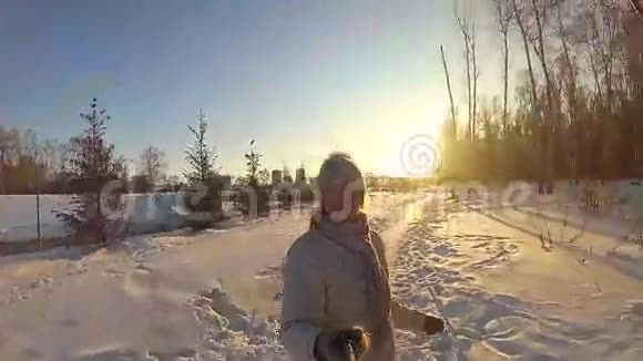 阳光明媚的冬天女孩在冬季公园自拍视频的预览图