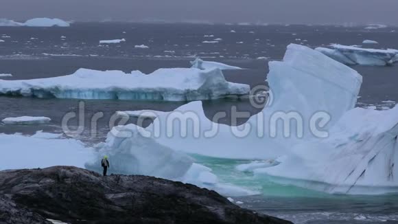 一位游客站在漂浮的冰山中间视频的预览图