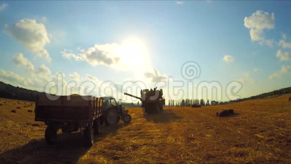 拖拉机和联合收割机在农活结束后离开农田视频的预览图