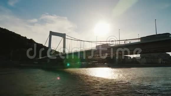 日落时分在布达佩斯的桥下游泳河流游船从浮动旅游船上观赏视频的预览图