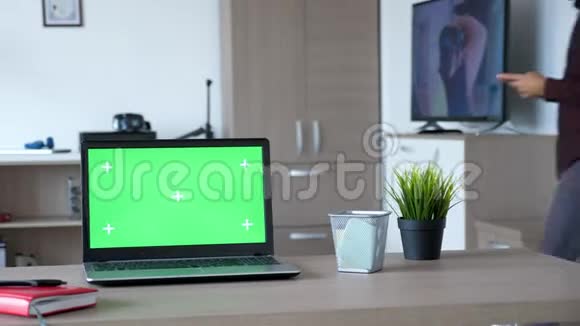 现代笔记本电脑桌面上有一个独立的绿色屏幕模型视频的预览图