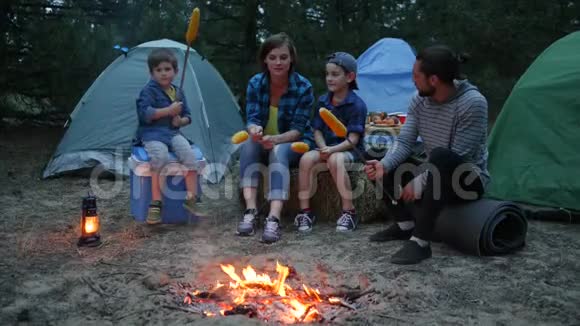 旅行营地妈妈孩子和爸爸在火烤玉米家庭晚上野餐户外美国家庭在视频的预览图