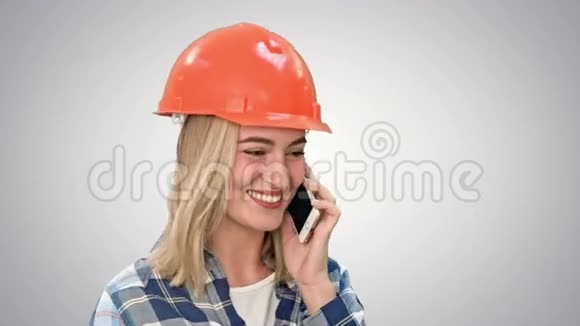 漂亮的女工程师在哈达通过手机在白色背景下打电话视频的预览图