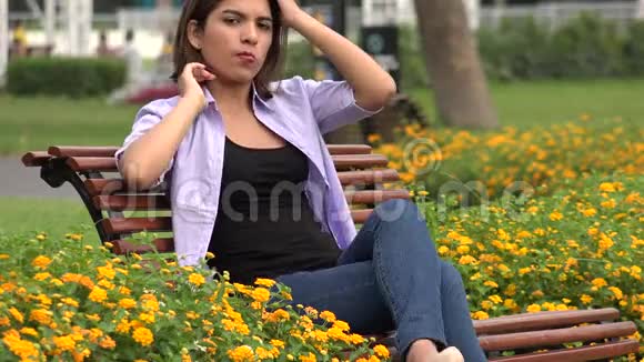 坐在公园长凳上的女青少年视频的预览图