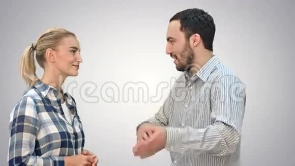 英俊的男人和迷人的年轻女人在白色的背景上交谈和微笑视频的预览图