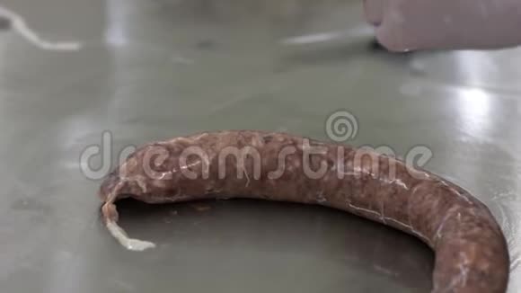 工人把肉装在贝壳里用网把它绑起来香肠制作过程视频的预览图