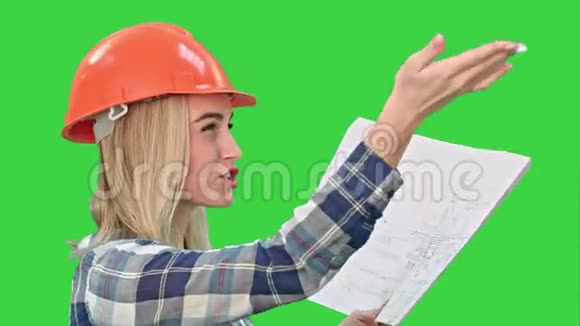 女建筑工程师在绿色屏幕上阅读计划并与工人交谈Chroma键视频的预览图