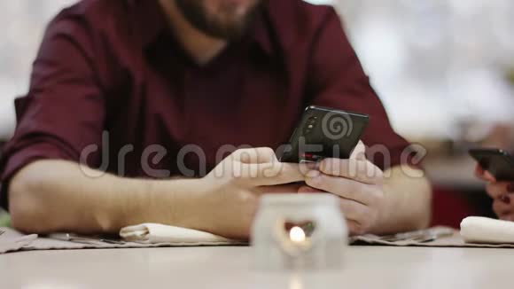 餐馆里坐着智能手机的成年商人视频的预览图