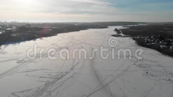 镜头在冬天和渔民一起飞越冰冻的河流空中观景摄像机沿着半径飞行4k视频的预览图