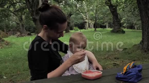 4k美丽的年轻妈妈正在橡树园的Ood乡村餐桌上给她一年的自制饭菜视频的预览图