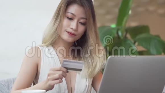 使用电脑以信用卡进行网上购物的亚裔妇女视频的预览图