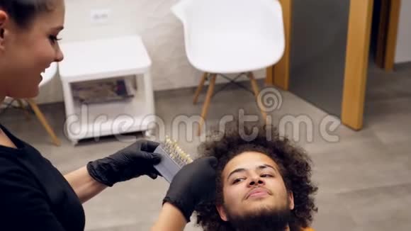 一名牙医助理检查一名年轻人牙齿颜色的阴影视频的预览图