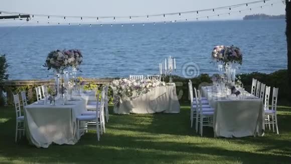美丽的桌子设置与陶器和鲜花的聚会婚宴或其他节日活动在海岸上视频的预览图