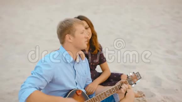 夏天一家人坐在沙滩上弹吉他唱歌视频的预览图