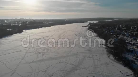 镜头在冬天和渔民一起飞越冰冻的河流空中观景摄像机沿着半径飞行4k视频的预览图