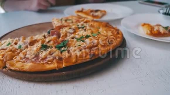 女人手切块披萨放在咖啡厅的盘子里视频的预览图